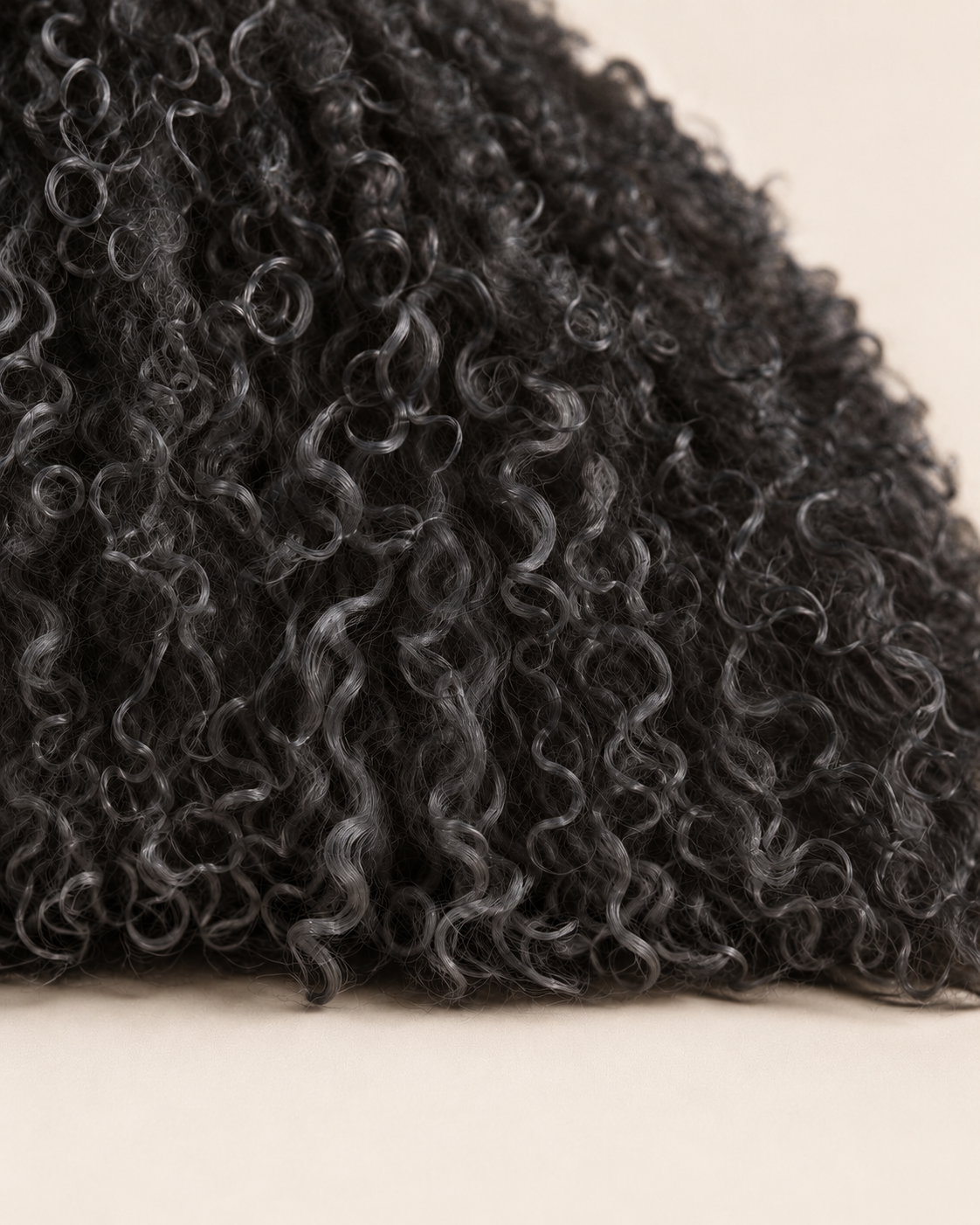 Close-up of the black cushion's curly Mongolian sheepskin texture