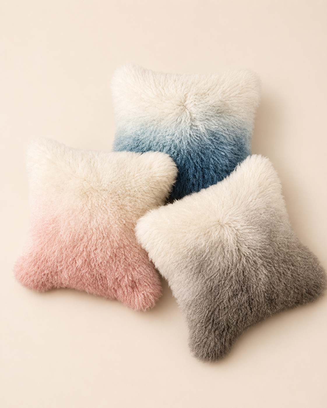 Pink, blue, and grey ombre Mongolian sheepskin cushions shown together; sold separately